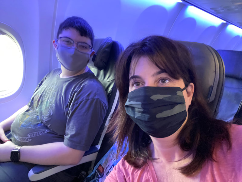 Dr. Lanya McKittrick with son Connor, seated on a plane wearing face masks.
